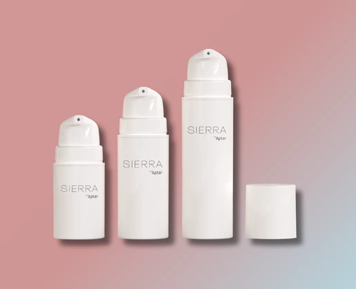 Three white cylindrical cosmetic pump bottles labeled SIERRA by Aptar are displayed on a pink and blue gradient background. One bottle cap is removed and placed to the side, showcasing the adaptable airless packaging design.