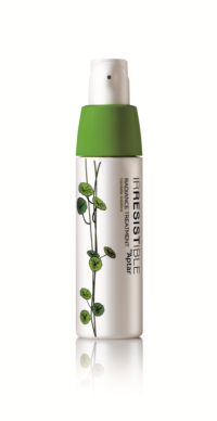 A white bag-in-bottle airless Irresistible Radiance Treatment by Aptar with th a green cap and green plant illustrations on the front, shown on a white background.