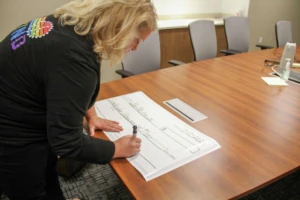 Aptar employee signing the donation check.
