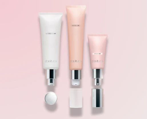 Three Dositube prestige airless pump tubes in pastel shades with silver caps, vertically aligned on a light pink background. Premium packaging ideal for skincare, featuring airless dispensing technology