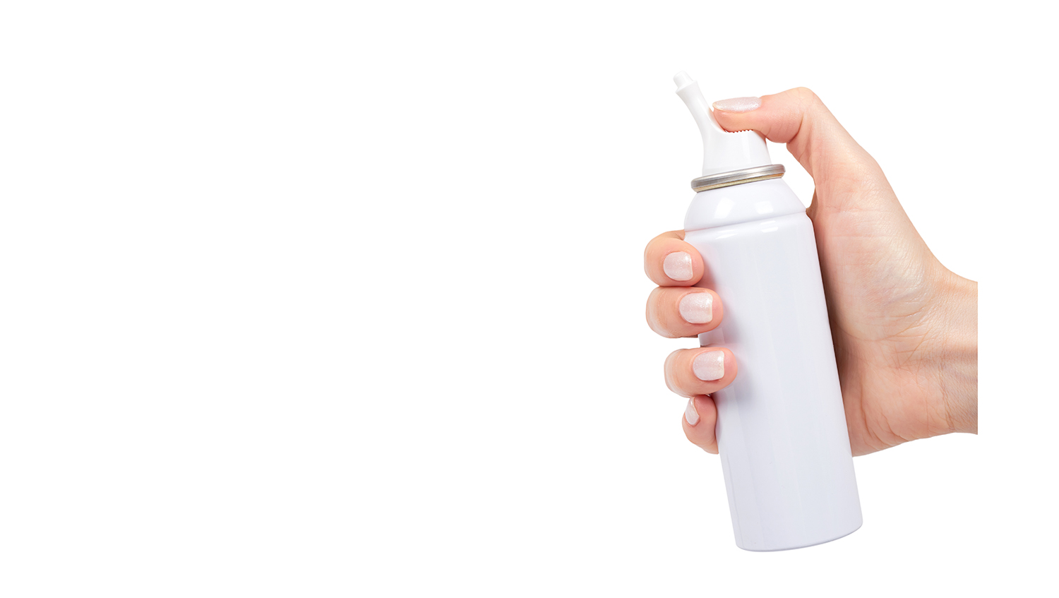 A hand holding a white nasal spray bottle with Aptar Pharma’s Bag-On-Valve technology, pressing the nozzle to release the product, demonstrating ease of use.