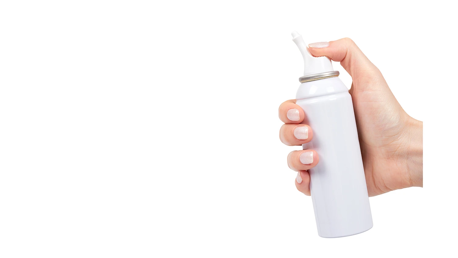 A hand holding a white nasal spray bottle with Aptar Pharma’s Bag-On-Valve technology, pressing the nozzle to release the product, demonstrating ease of use.