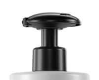 Close-up of Vita, a black push down dispensing pump on top of a white bottle, set against a plain white background.