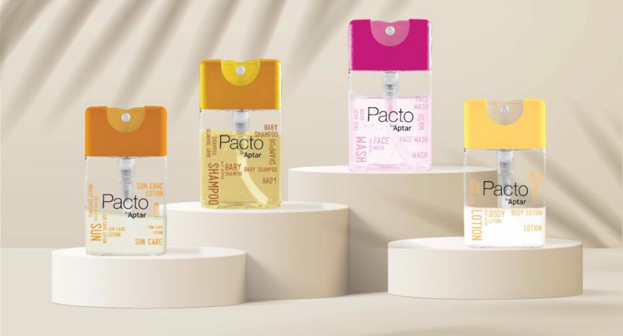 Four Purette Lotion bottles with flat mini packaging , each with a colorful cap : pink and yellow are displayed on beige circular platforms. The label reads 'Pacto by Aptar,' highlighting the compact format.