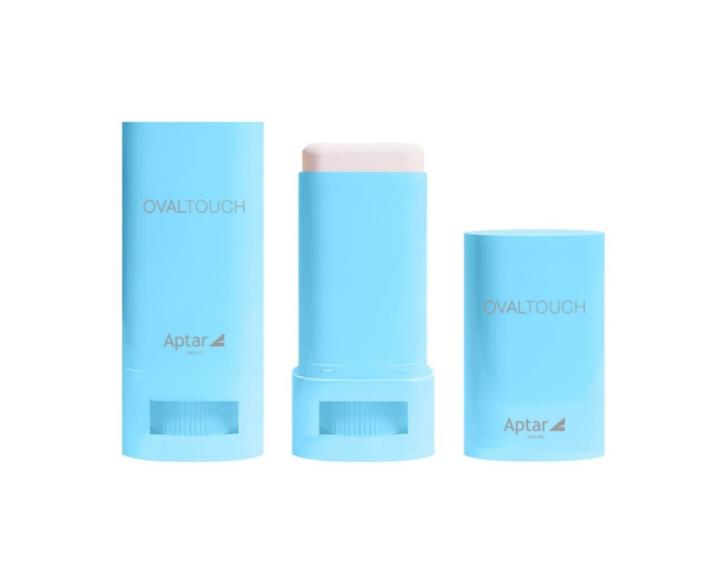 Two light blue Oval Touch on-the-go oval face stick containers labeled OVALTOUCH and Aptar beauty, standing upright against a soft blue gradient background. The first one is closed, middle container is open, revealing the white sick inside followed by the one cap.