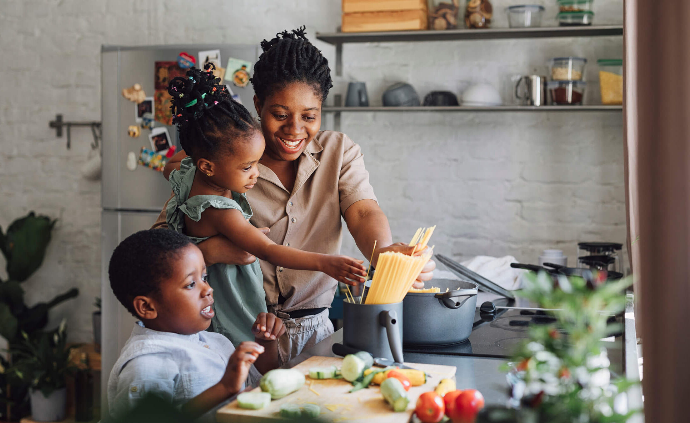 Family cooking pasta in kitchen