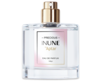 A clear glass perfume bottle with a prestige fragrance pump and gold spray nozzle, labeled Precious INUNE by Aptar, Eau de Parfum, 100 ml on a white and pale pink label.