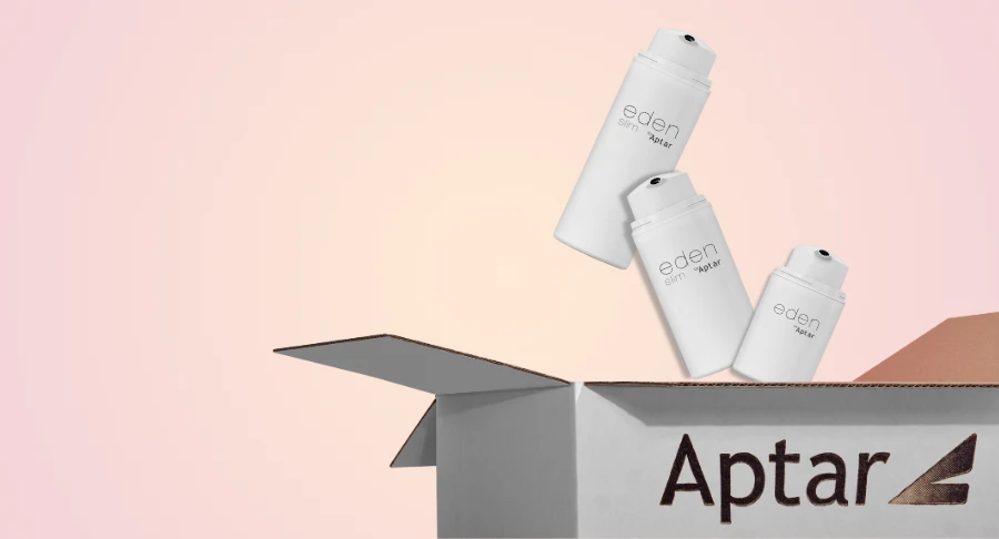 Three white airless packaging for skincare bottles labeled Eden are falling into an open cardboard box labeled Aptar against a light pink gradient background.