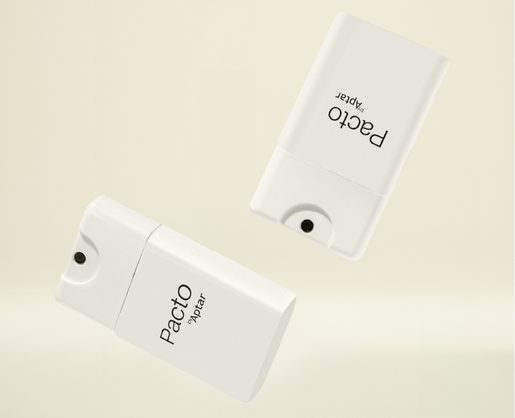 Two white rectangular spray bottles labeled Pacto, featuring pocket size spray packaging, float against a light beige background one upright and the other upside down.
