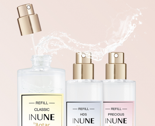 Three clear perfume bottles with gold fragrance pumps are shown. One bottle is being refilled using a high definition spray fragrance pump. Labels read REFILL CLASSIC, REFILL HDS, and REFILL PRECIOUS by Aptar.