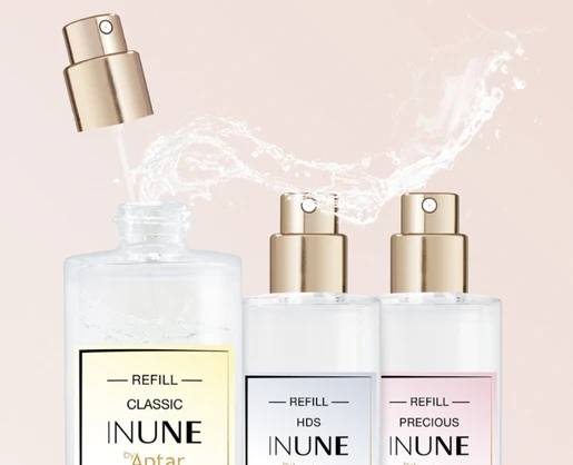 Three clear perfume bottles with gold fragrance pumps are shown. One bottle is being refilled using a high definition spray fragrance pump. Labels read REFILL CLASSIC, REFILL HDS, and REFILL PRECIOUS by Aptar.