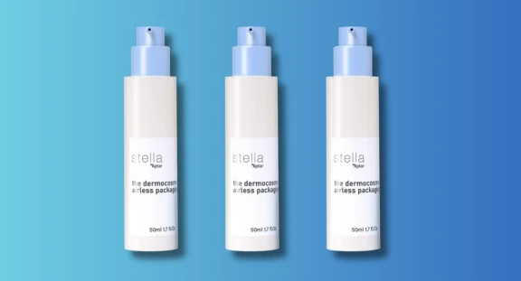 A group of cream bottles with blue caps, featuring a versatile airless dispenser labeled Stella by Aptar in black text,against a gradient blue background.
