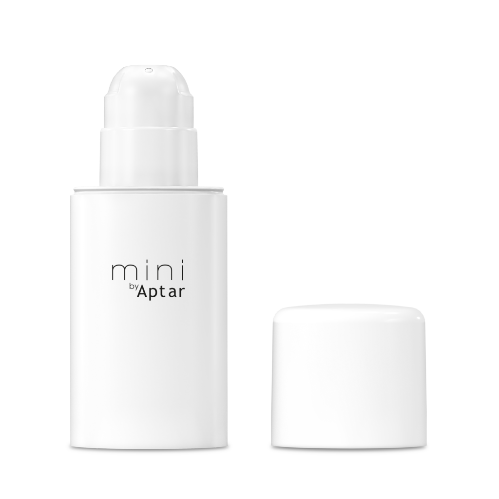 A white mini airless packaging labeled Mini by Aptar  stands next to its matching white cap on a plain background.