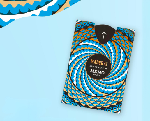 A perfume box labeled MADURAI MEMO PARIS with a bold, geometric blue, white, black, and gold circular pattern on a light blue background. Ultra-flat fragrance sampling packaging is partially visible in the top left corner.
