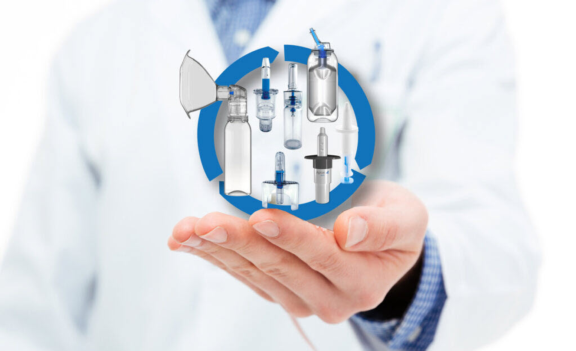 Man in white lab coat holding range of Aptar Pharma Nasal devices developed for customer requirements.