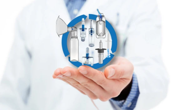 Man in white lab coat holding range of Aptar Pharma Nasal devices developed for customer requirements.