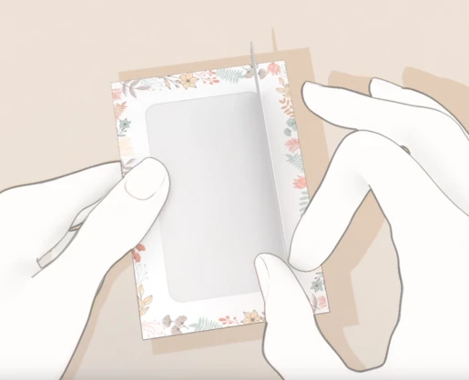 Illustration of Aptar Beauty's SCENTDOW paper fragrance sampling solution in use. A white card with a transparent window is partially pulled from a product display, revealing the scent delivery area