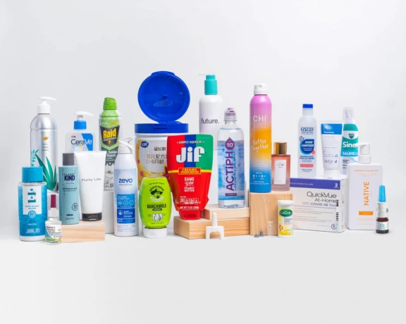 Assorted household and personal care products, including soaps, sprays, food containers, and health items, displayed side by side on a white background
