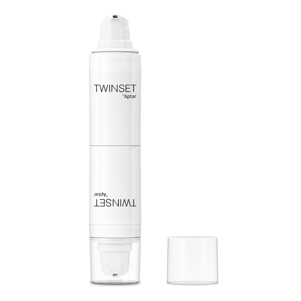 A white dual-chamber pump bottle labeled TWINSET Aptar, designed with innovative 2-in-1 Airless Packaging, stands upright with a clear plastic cap placed next to it on a white background.