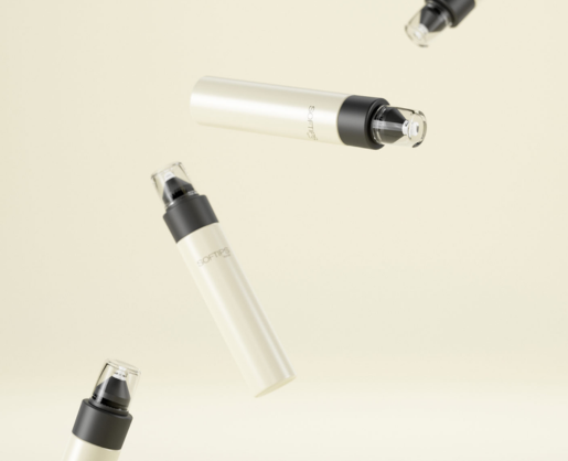 Four sleek, cream-colored bottles with a beauty treatment applicator named Softips float against a light beige background. Each bottle has a clear cap.
