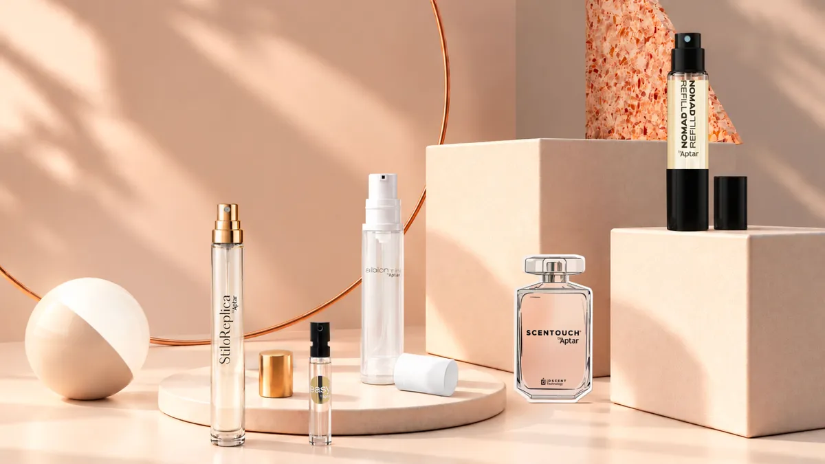 A collection of fragrance sampling solutions and mini packaging formats, including spray vials, refillable travel sprays, and fragrance samplers, is displayed on decorative podiums.