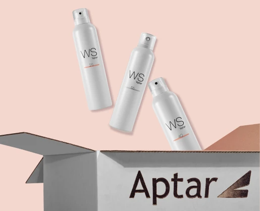 Three white bottles labeled WS40, WS55, and WS25 float above an open Aptar-branded cardboard box on a soft pink background. The WS25 bottle features a modern aerosol actuator.