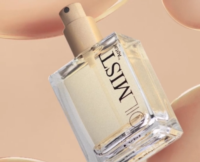 A clear rectangular perfume bottle labeled OIL MIST with a gold spray pump for dry oils is shown against a beige background with abstract, translucent circular shapes.