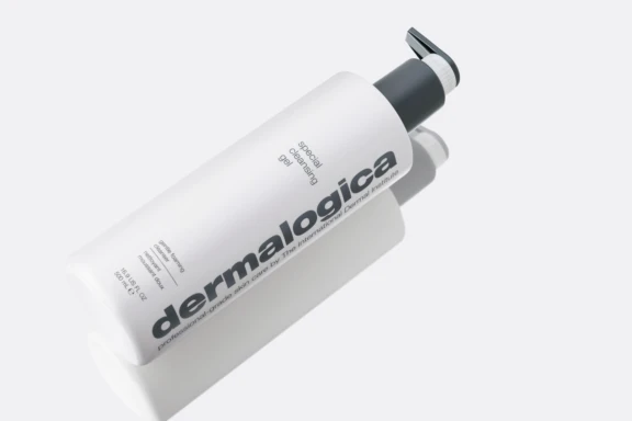 A white bottle of Dermalogica Special Cleansing Gel featuring Future,  a fully recyclable dispensing pump lies on its side against a light background. The label features bold gray text, and a subtle shadow is cast beside the bottle.