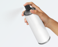 A hand holding and spraying a white aerosol can with an Aerosol Actuator with Built In Tube named Akur against a plain light background.