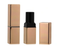 Two metallic rose gold rectangular non guided lipstick packaging are displayed on a white background : one is open, revealing a sleek black inner casing, while the other remains closed.