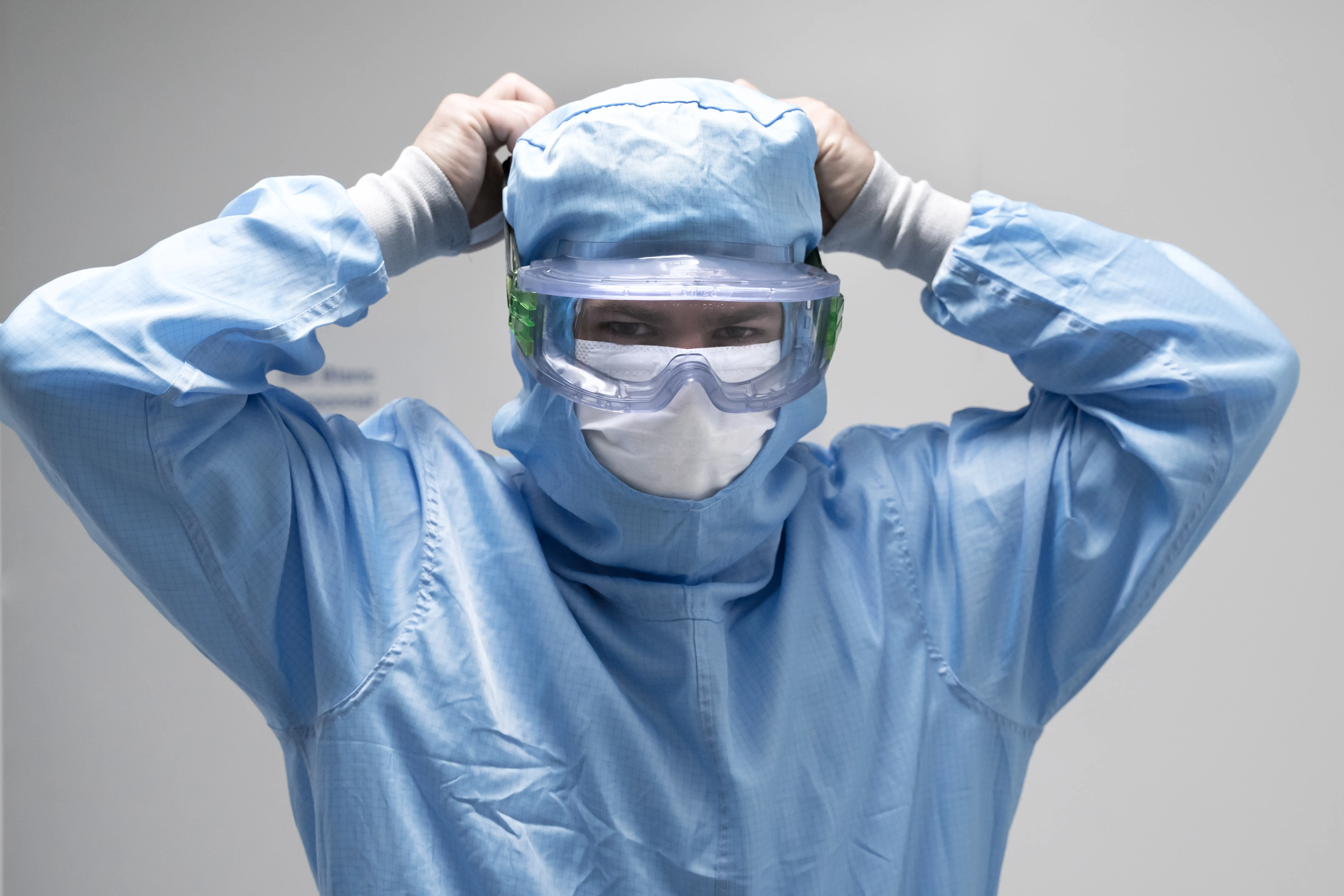 Pharmaceutical cleanroom operator preparing GMP‑controlled handling of elastomeric stoppers and plungers for injectable drug manufacturing under sterile conditions.