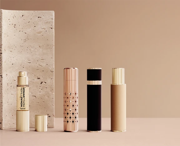 Nomad Refill, a refillable travel fragrance sprays in a variety of premium decorative finishes are displayed against a neutral backdrop, highlighting portable fragrance packaging solutions.