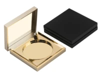 A gold compact makeup case with a mirror is open next to a closed black square case. Ideal for showcasing products from a custom cosmetic packaging manufacturer, the open case features an empty circular compartment for powder or makeup.
