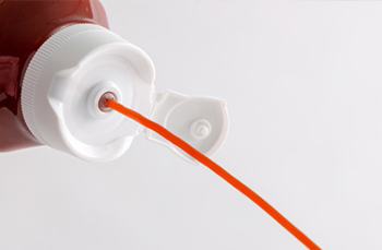 a close up image of ketchup being squeezed out of the bottle, cleanly, thanks to the flow control valve