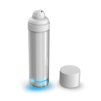 Aptar Pharma's C Dermal Airless Plus, featuring a sleek, transparent cylindrica body and a white spray nozzle. The white cap is placed beside the bottle, and a faint blue light glows from the base.