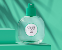 A clear round bottle with a PCR fragrance pump, labeled COLOR CODE PCR Aptar, is displayed on a turquoise background with matching geometric shapes and soft shadows.