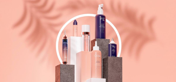Aptar's targeted application collection, featuring Softips, a beauty treatment applicator, along with Serumony and PZ is arranged on geometric platforms against a peach backdrop.