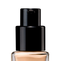 Close-up of a chic and premium cosmetic pump named Evolux with a black dispenser and beige liquid inside, set against a white background.