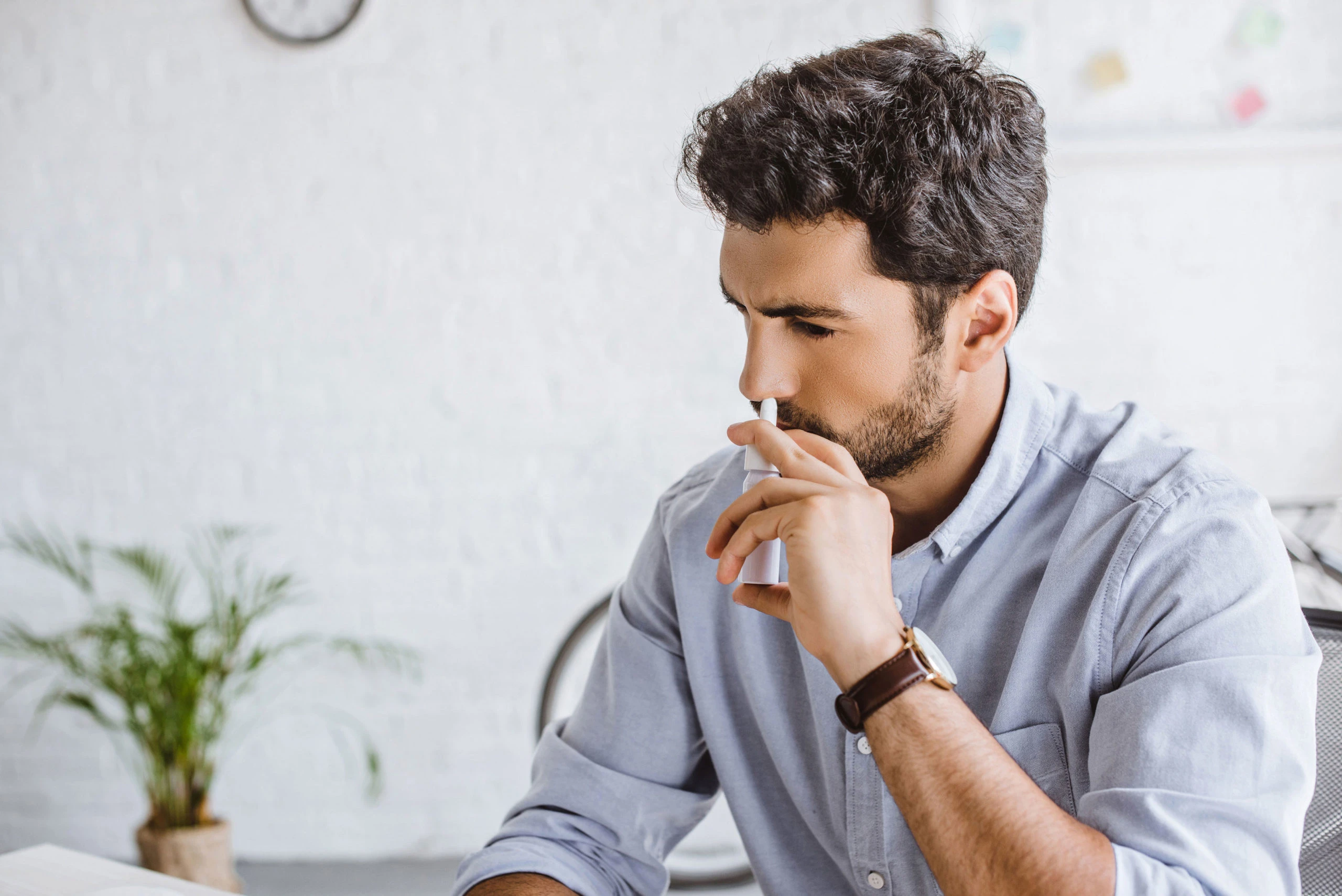 young man using nasal spray