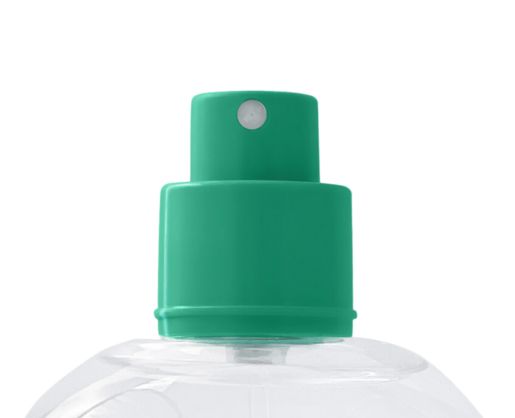 A close-up of a green Color Code PCR fragrance pump on a clear plastic bottle, set against a white background.