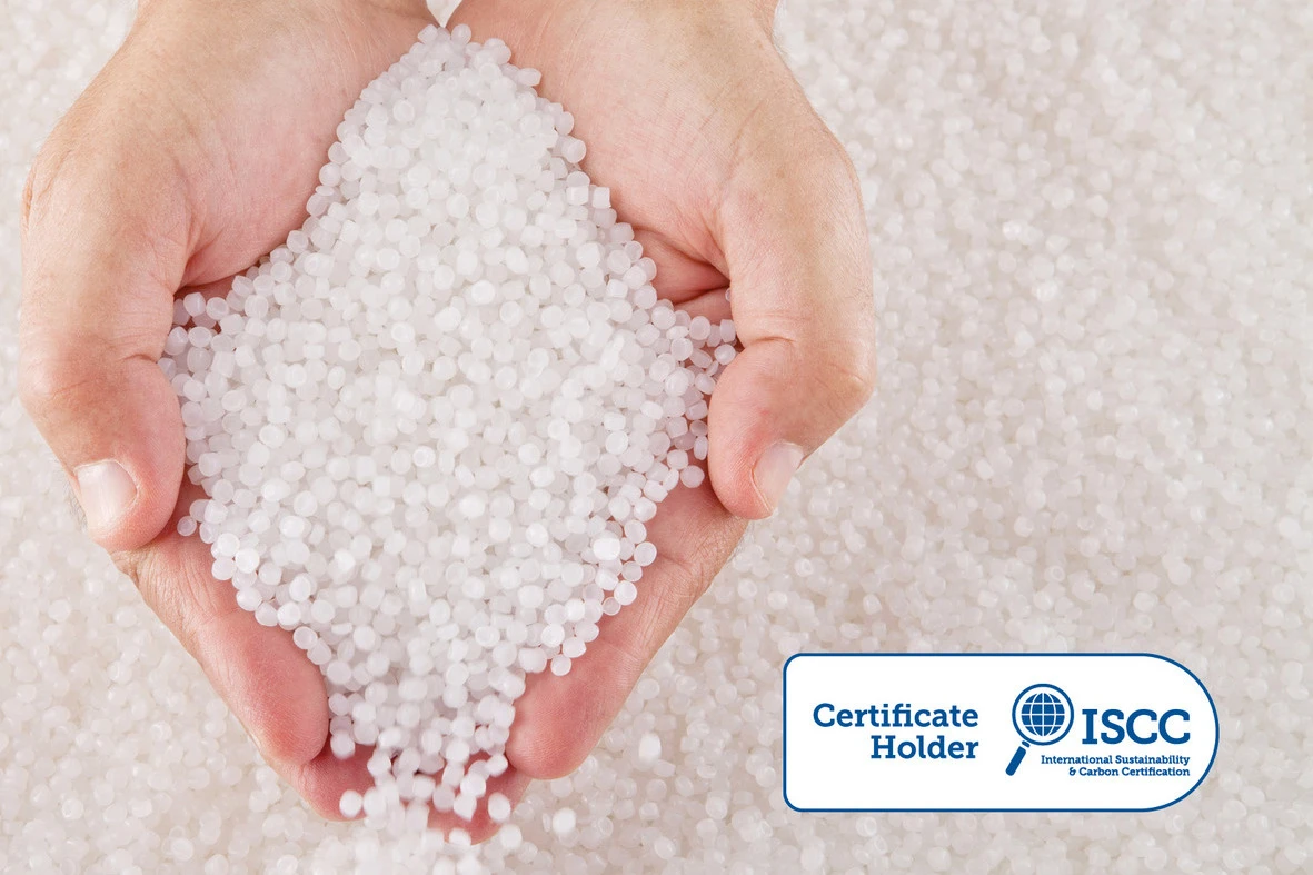 Two human hands holding small beads of recycled circular feedstock materials for APF futurity devices.