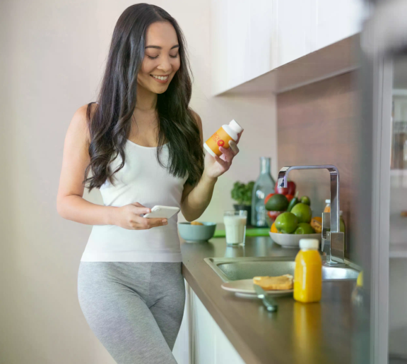 Woman handling a probiotic bottle using 3-Phase Activ-Polymer™ Technology
