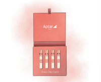 An illustration of pink rectangular box labeled Aptar Beauty contains four small, clear vials with orange pumps for fragrance sampling named Easy Spray, neatly arranged in a row. The inside flap reads Easy Clip Card on a soft pink background.