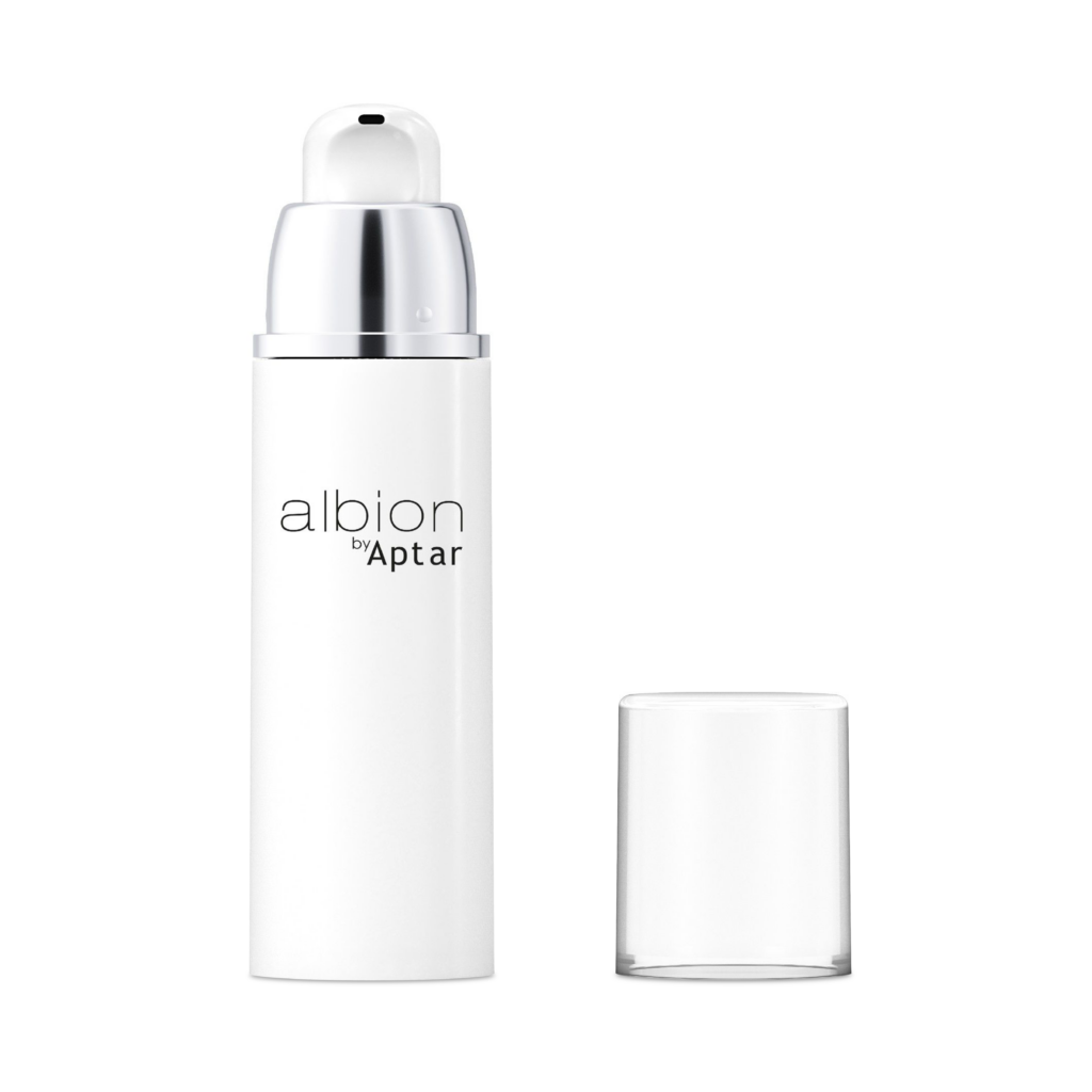 A white cosmetic pump bottle labeled "Albion by Aptar" stands upright on a plain white background. The bottle features Aptar’s airless beauty packaging, designed to protect sensitive formulations. Its clear cap is removed and placed beside it.