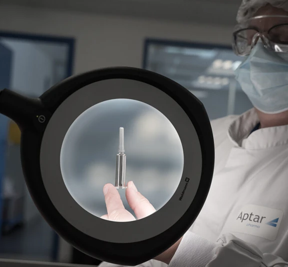 Aptar Pharma’s expert in rubber formulation and product design holding a pre-filled syringe with a needle shield