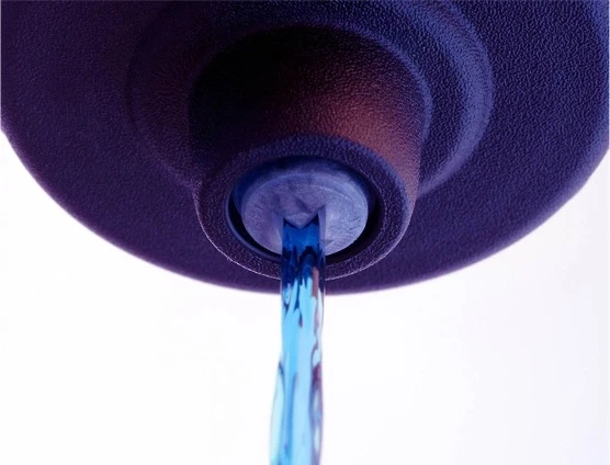 A person wearing pink gloves cleans a blue surface with a blue cloth and green sponge. On the right, a white aerosol can labeled Gladiator, an ergonomically-designed aerosol actuator, next to a pink sponge.