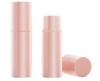 Two pink cylindrical face sticks are displayed on a white background, two standing and one cap lying down.