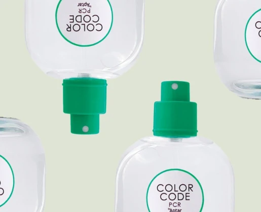 Four clear bottles, feature a Color Code PCR fragrance pump. Arranged on a light beige background, the bottles are displayed from different angles some upright and some upside down.