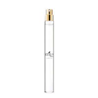 A slim, clear glass perfume spray bottle labeled STILO in black text, featuring a gold fragrance pump. This refillable mini packaging by Aptar is designed for on-the-go scent sampling.