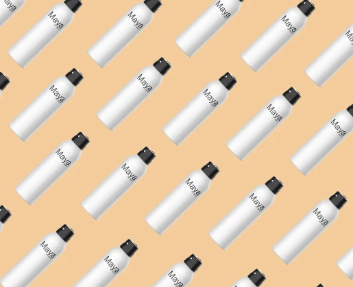 A seamless pattern of white aerosol cans labeled Maya, a premium and customizable aerosol actuator molded in black, is arranged diagonally on a peach-colored background, repeating evenly across the image.